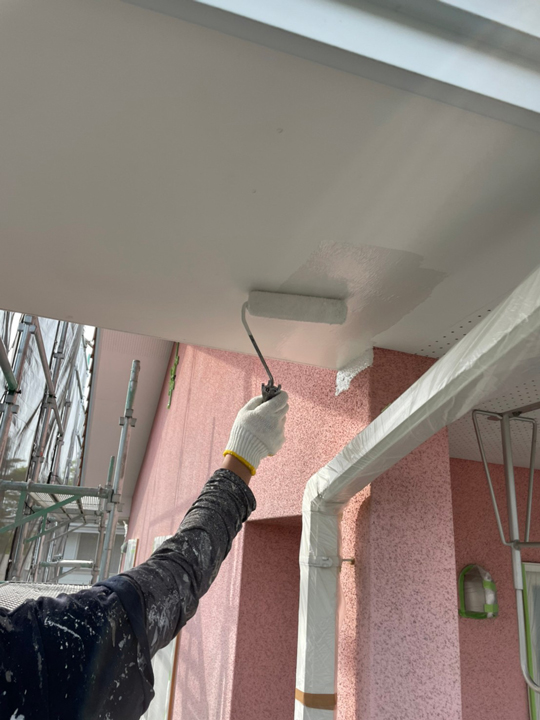 軒天の塗装を行います。<br />
ピンクの外壁塗装が映えるように白色で塗装していきます。